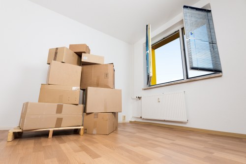 Professional movers carrying boxes in a Kilburn apartment building